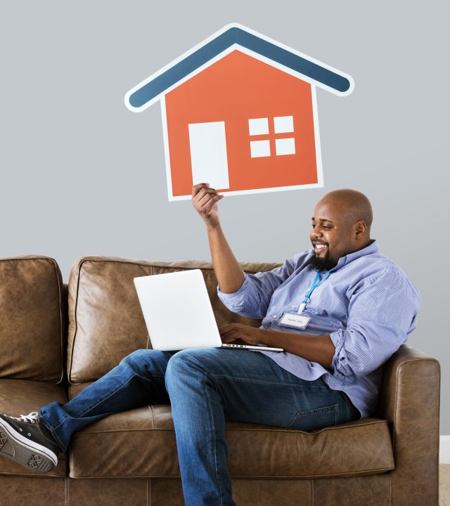 Man showing house icon on couch